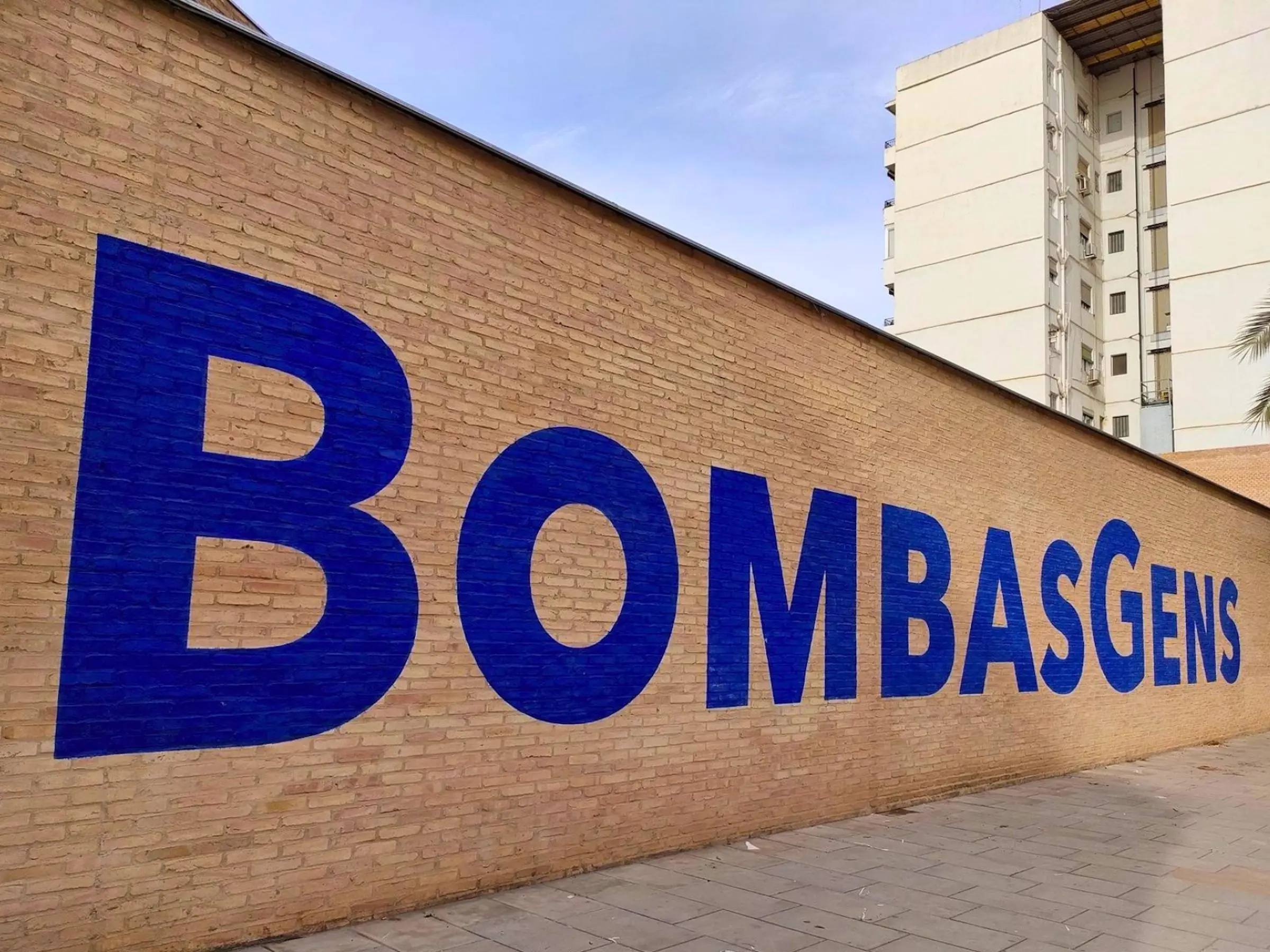 Bombas Gens Exterior Sign Large blue painted Bombas Gens sign on an exterior brick wall