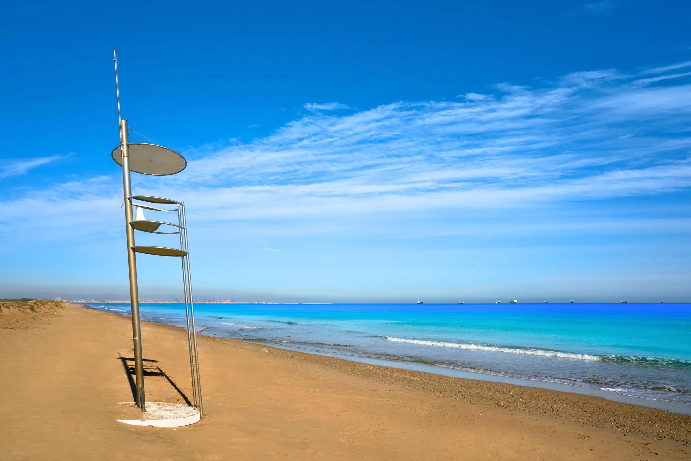 A modern metal lifeguard tower on the wide golden sands of El Saler beach