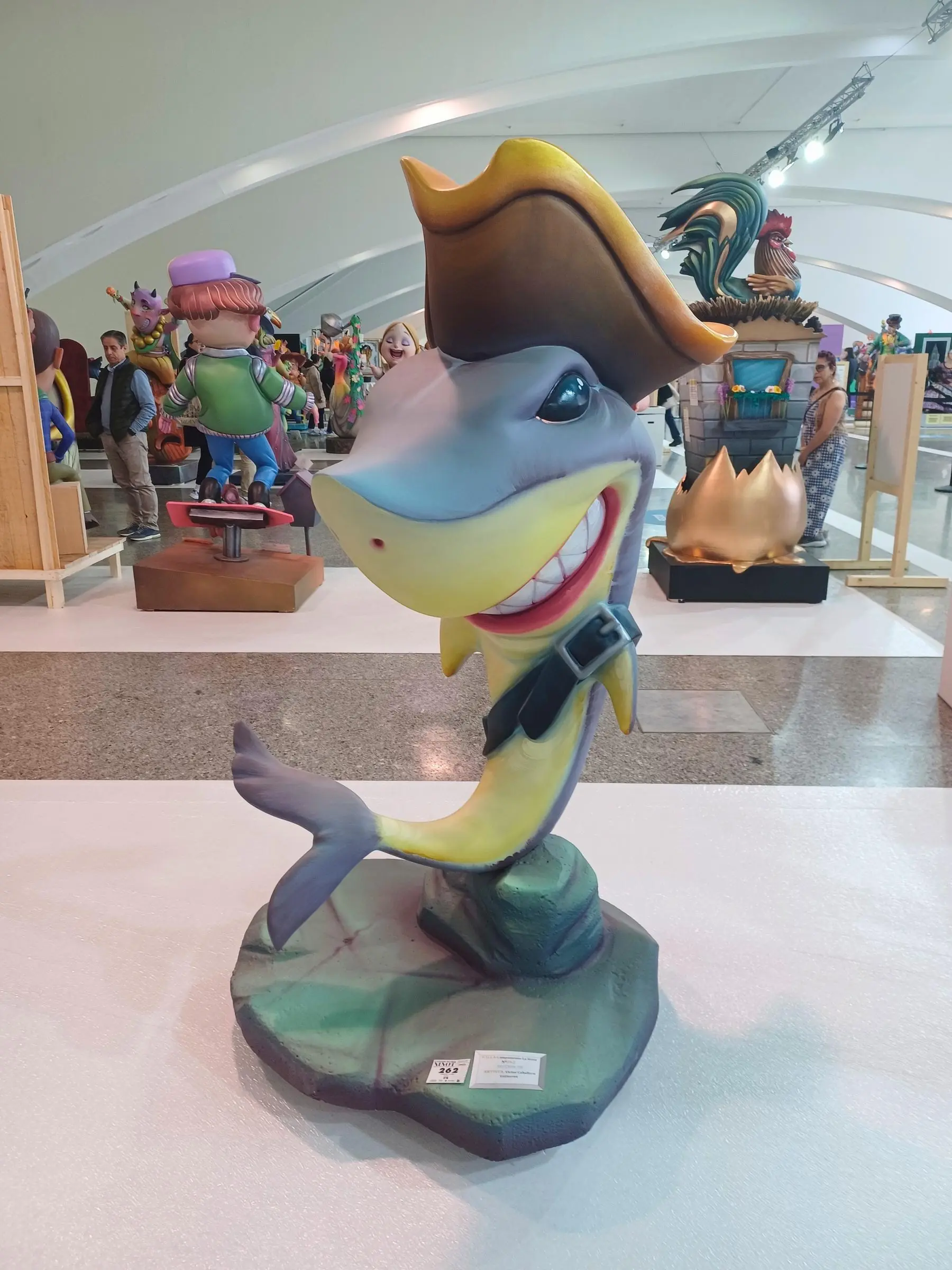 A modern, brightly colored Ninot statue of a smiling shark wearing a pirate hat