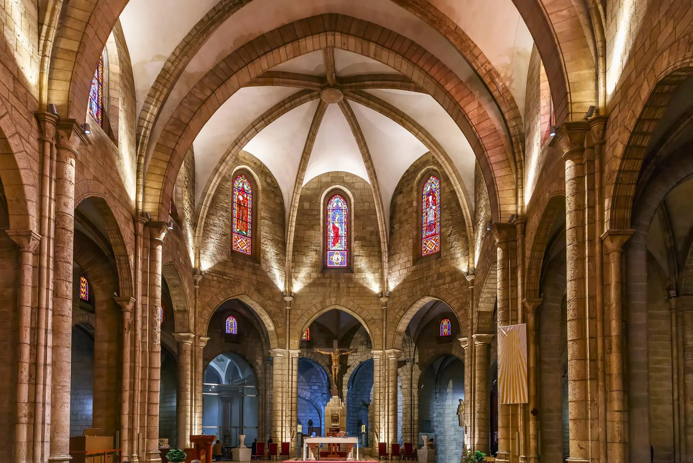 High ribbed vaults and raw stone columns inside the Gothic nave of Santa Catalina Church