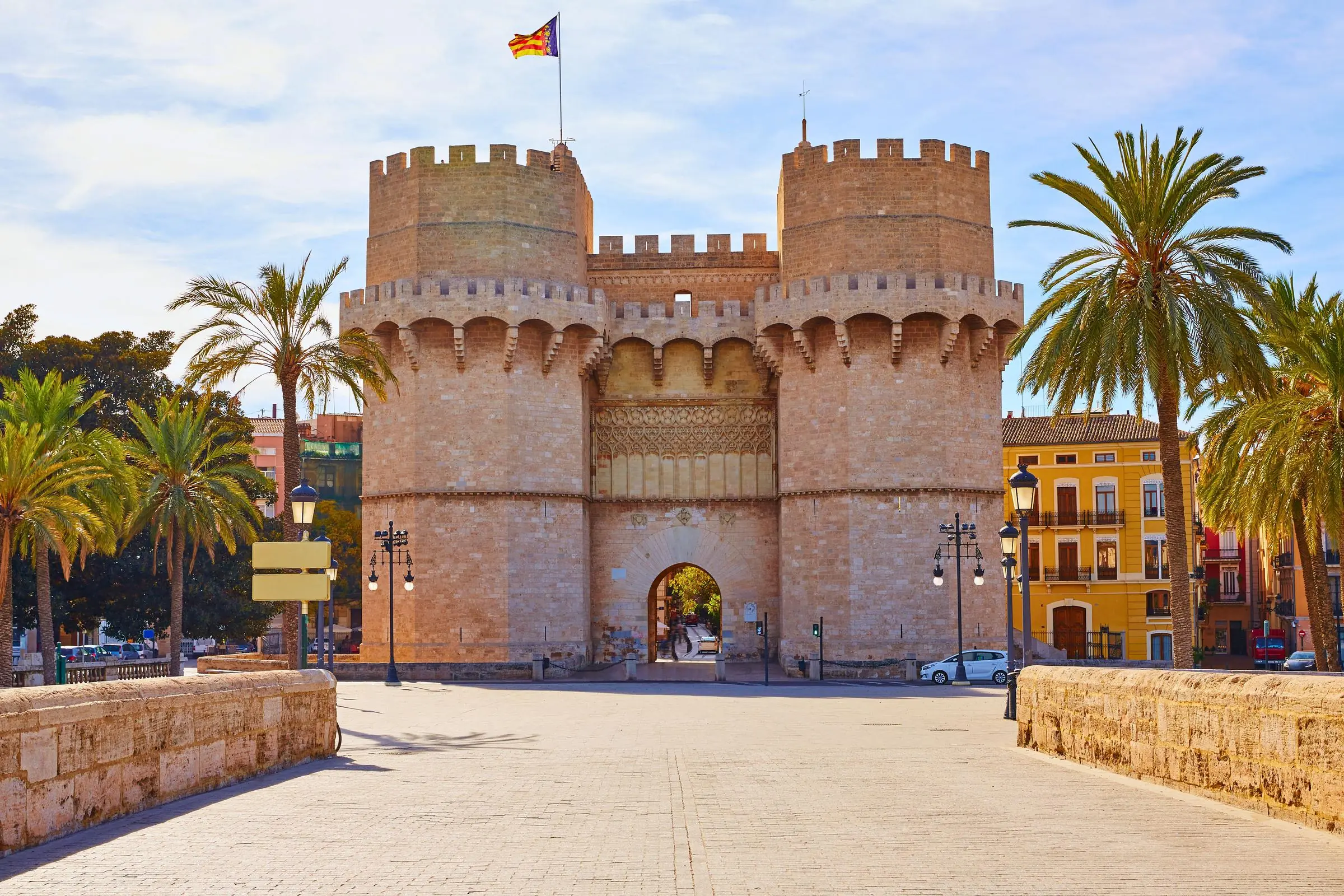 The imposing stone facade of the Serranos Towers facing the Turia Gardens in Valencia
